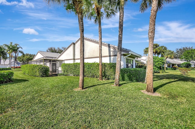 view of side of property with a sunroom and a yard