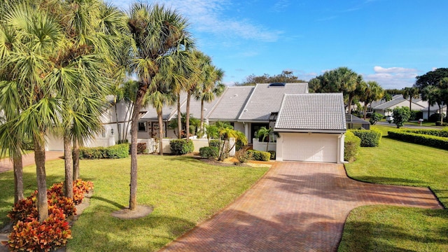 view of front of property featuring a garage and a front lawn