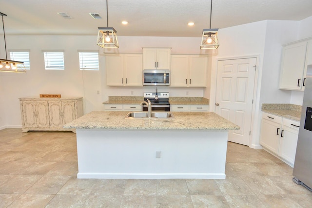 kitchen featuring pendant lighting, a center island with sink, white cabinetry, and appliances with stainless steel finishes