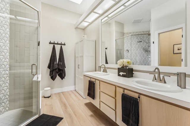 bathroom with vanity, a shower with shower door, and hardwood / wood-style floors