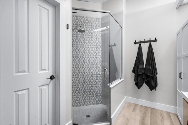 bathroom featuring a shower with door, vanity, and hardwood / wood-style floors