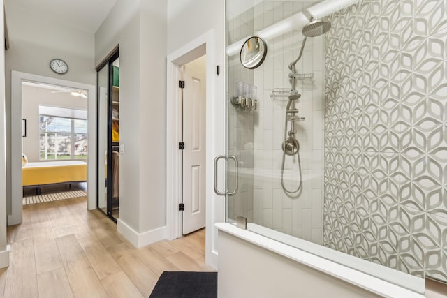 bathroom with wood-type flooring and a tile shower