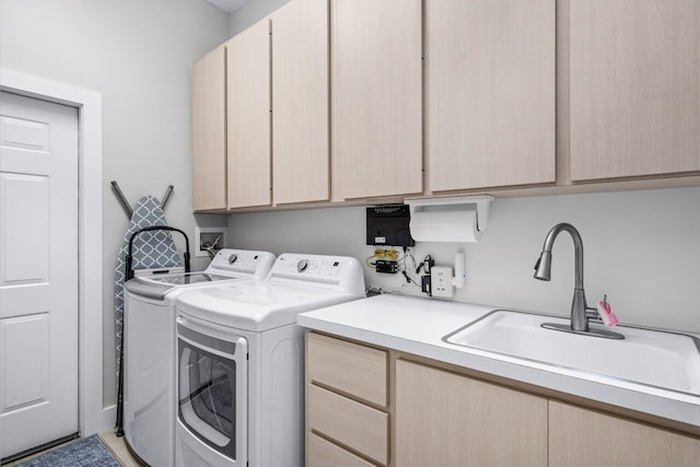 washroom with sink, cabinets, and washer and dryer