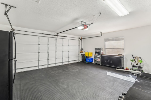 garage with a garage door opener and black refrigerator