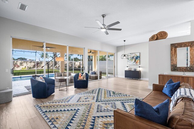 living room featuring ceiling fan and light hardwood / wood-style floors