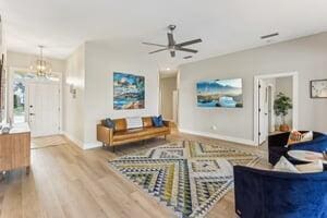 living room featuring hardwood / wood-style flooring and ceiling fan with notable chandelier