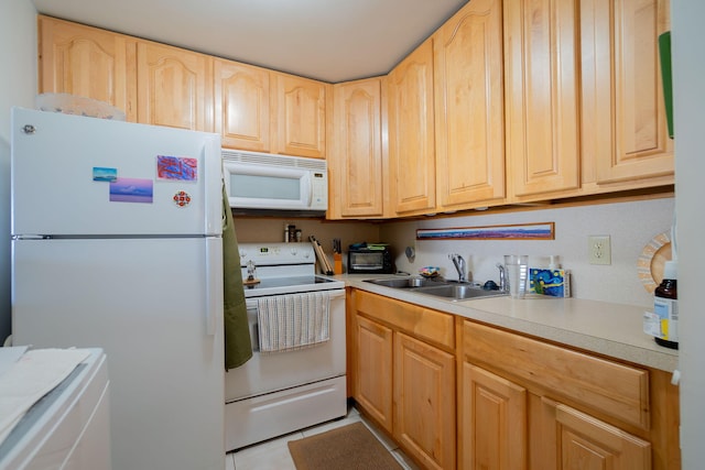 kitchen featuring light tile patterned floors, light countertops, light brown cabinetry, a sink, and white appliances