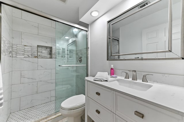 bathroom featuring vanity, toilet, and an enclosed shower