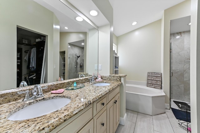 bathroom featuring plus walk in shower, vanity, and tile patterned flooring