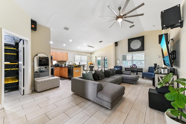 living room featuring ceiling fan, lofted ceiling, sink, and a wealth of natural light