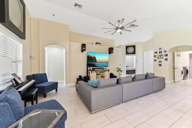 tiled living room featuring separate washer and dryer, ceiling fan, and lofted ceiling