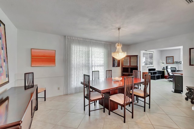 tiled dining space with a chandelier