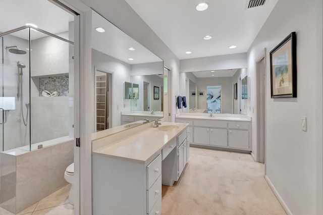 bathroom with vanity, a shower with shower door, and toilet