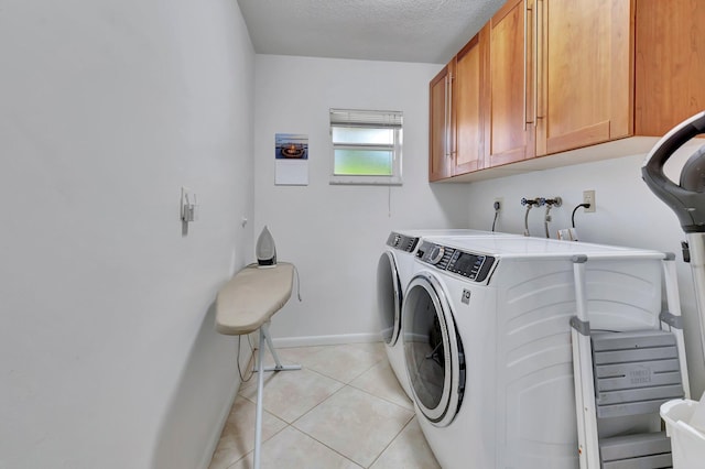 laundry area featuring light tile patterned flooring, cabinets, separate washer and dryer, and a textured ceiling