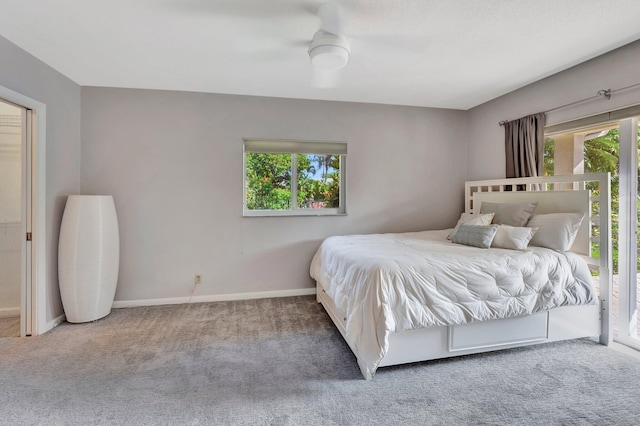 carpeted bedroom with access to outside, multiple windows, and ceiling fan