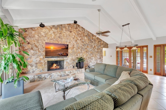 living room with french doors, ceiling fan, light tile patterned floors, beamed ceiling, and a stone fireplace