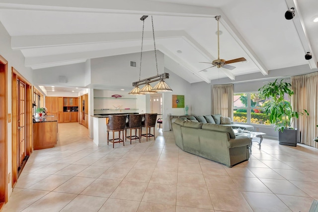 living room with vaulted ceiling with beams, ceiling fan, and light tile patterned flooring