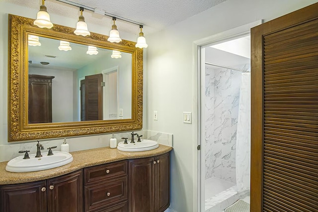 bathroom with curtained shower, vanity, and a textured ceiling