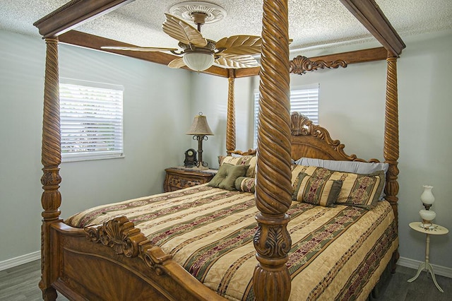 bedroom featuring multiple windows, a textured ceiling, dark hardwood / wood-style flooring, and ceiling fan