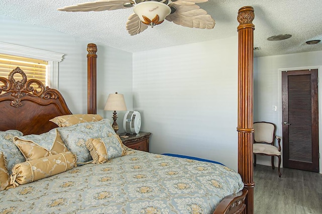 bedroom with hardwood / wood-style floors, a textured ceiling, and ceiling fan