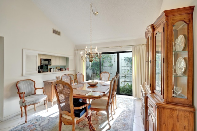 tiled dining room featuring a chandelier, a textured ceiling, and vaulted ceiling