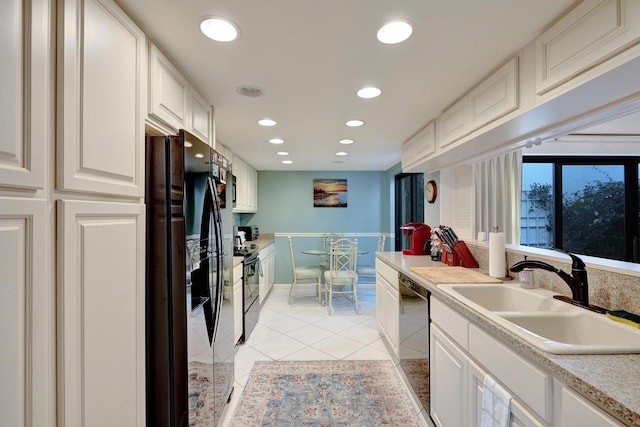 kitchen featuring white cabinets, light tile patterned floors, sink, and black appliances