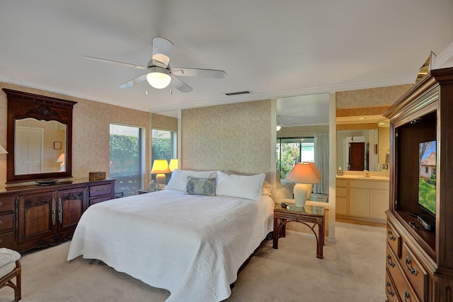 bedroom with connected bathroom, light colored carpet, ceiling fan, and crown molding