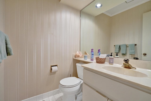 bathroom with tile patterned floors, crown molding, vanity, and toilet