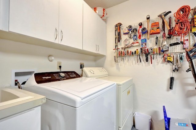 laundry area with cabinets, independent washer and dryer, and a workshop area