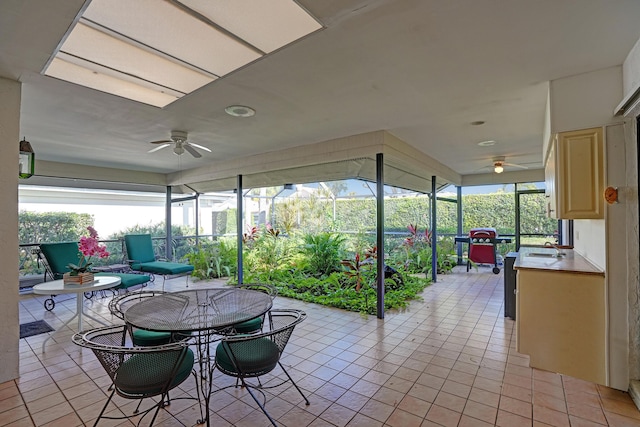 sunroom with ceiling fan and sink