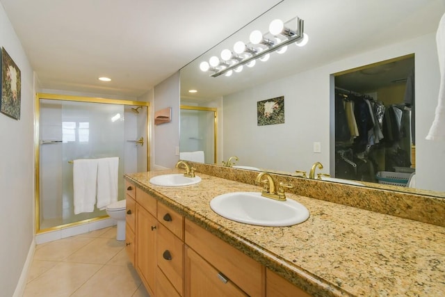 bathroom featuring toilet, vanity, tile patterned floors, and an enclosed shower