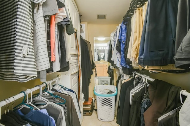 walk in closet with light tile patterned floors