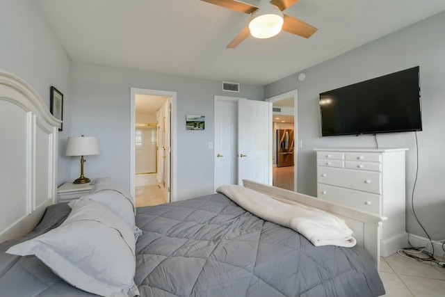 bedroom with ceiling fan, light tile patterned floors, and connected bathroom