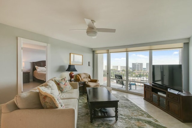 tiled living room with ceiling fan and floor to ceiling windows