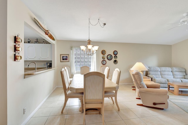 dining space with sink, light tile patterned flooring, and ceiling fan with notable chandelier