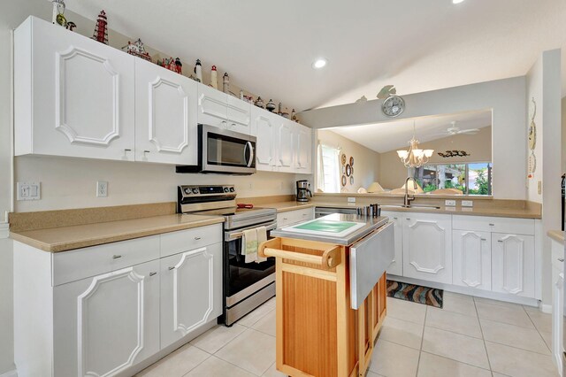 kitchen featuring white cabinets, sink, vaulted ceiling, kitchen peninsula, and stainless steel appliances