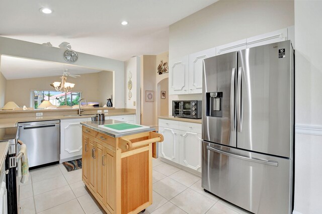 kitchen featuring a chandelier, a kitchen island, stainless steel appliances, and light tile patterned floors