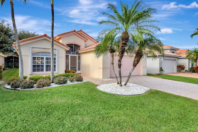 mediterranean / spanish house featuring a garage and a front lawn