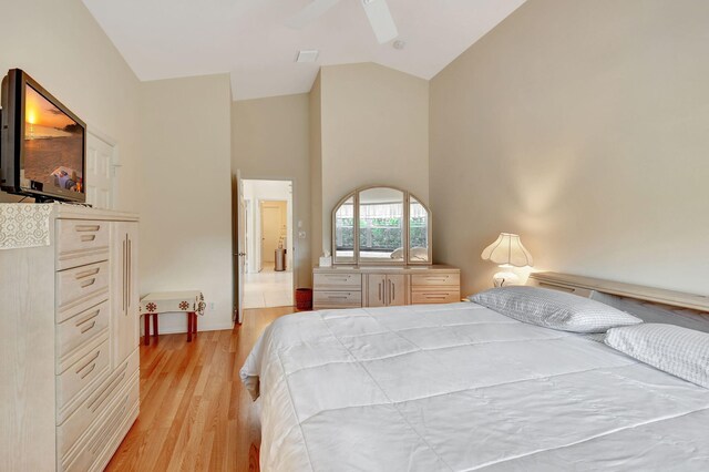 bedroom featuring light wood-type flooring, high vaulted ceiling, and ceiling fan