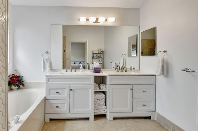 bathroom featuring tile patterned flooring, a bath, and vanity