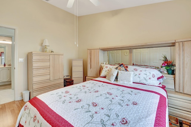 bedroom featuring ceiling fan, ensuite bathroom, and light wood-type flooring