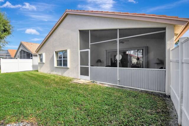 back of house featuring a sunroom and a yard