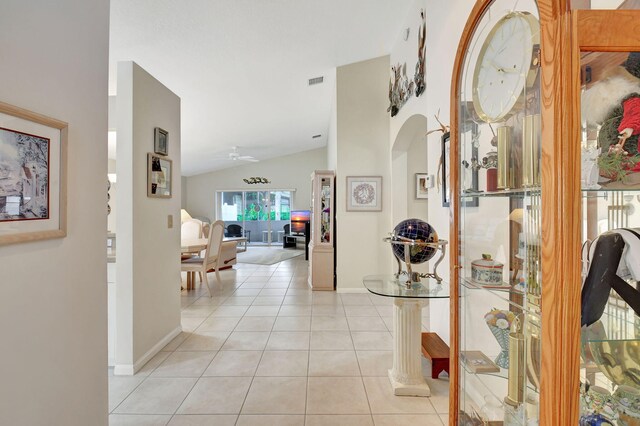 hallway with light tile patterned floors and lofted ceiling