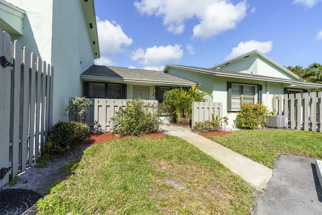 view of front of house featuring a front yard and central air condition unit