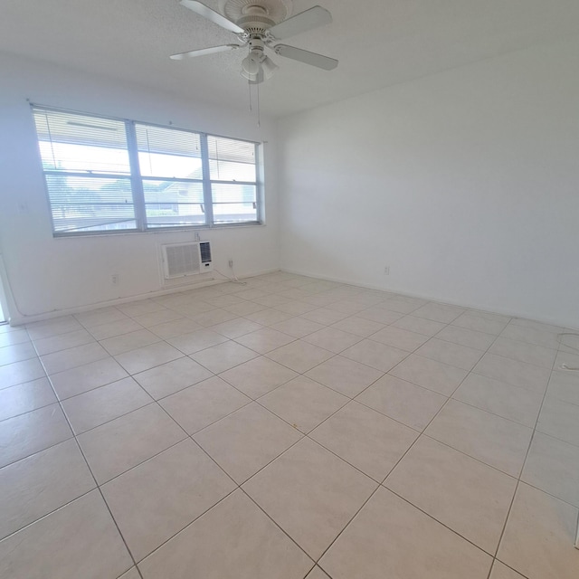 unfurnished room featuring light tile patterned floors, a wall mounted AC, and ceiling fan