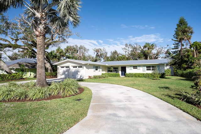 ranch-style home featuring a garage and a front lawn