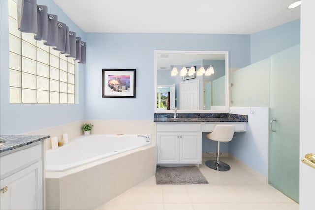 bathroom featuring vanity, tiled tub, and tile patterned floors