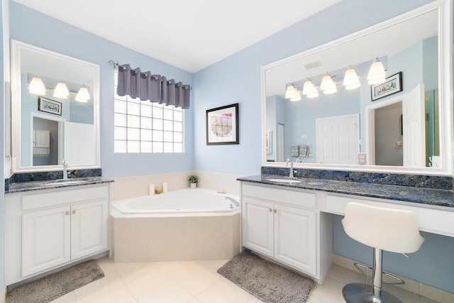 bathroom featuring vanity, tile patterned flooring, and a relaxing tiled tub