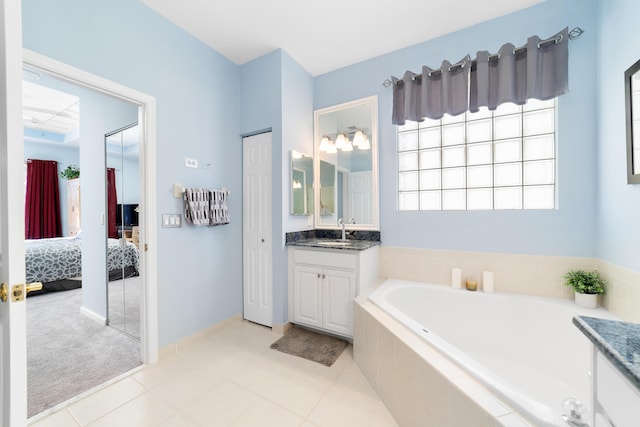 bathroom featuring a relaxing tiled tub, tile patterned flooring, and vanity