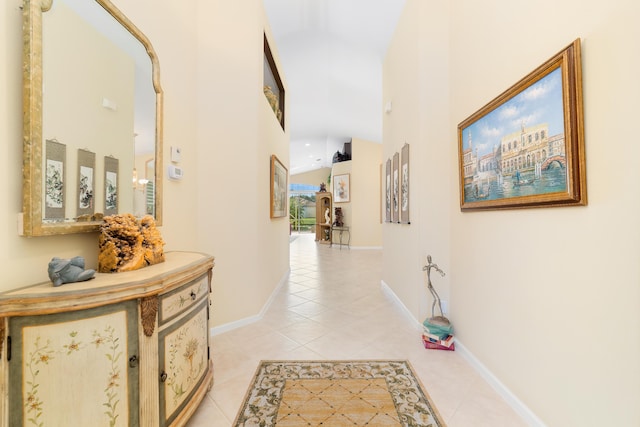 corridor featuring high vaulted ceiling and light tile patterned floors